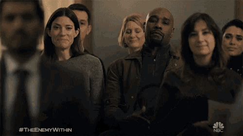 a group of people sitting in a room with a nbc logo in the background