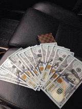 a fan of 100 dollar bills on a chair