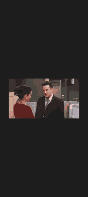 a man and woman kissing in a public restroom