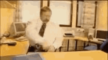 a man in a white shirt and tie is standing in an office