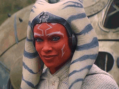 a woman with red face paint and striped ears is wearing headphones and a helmet .