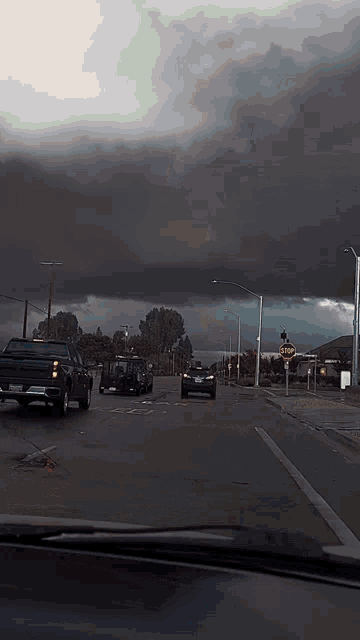 a dark cloudy sky with a stop sign in the distance