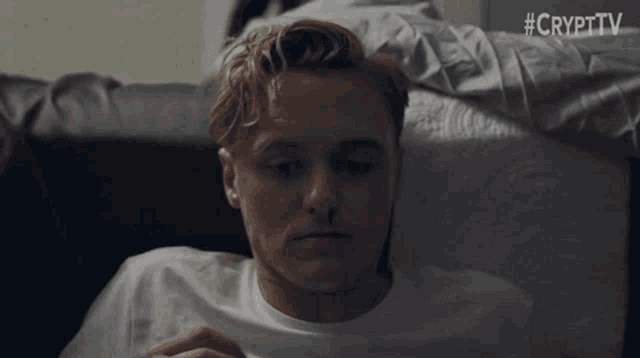 a man with a bloody nose is laying on a couch with #crypttv written on the bottom