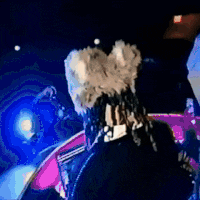 a woman with dreadlocks is playing a violin on stage