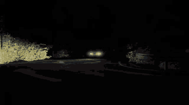 a car is driving down a dark road with smoke coming out of the back