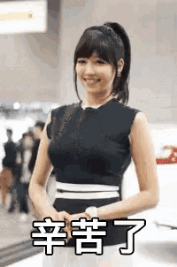 a woman is standing in front of a car with chinese writing on it .