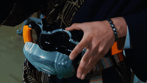 a person with a bracelet on their wrist holds a toy