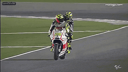 two motorcycle racers are racing on a track and the website motogp.com is visible in the corner