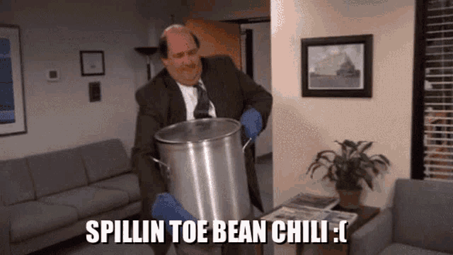 a man in a suit and tie is holding a large pot with the words spillin toe bean chili written on it