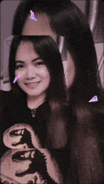a woman wearing a black shirt with a dinosaur on it is smiling