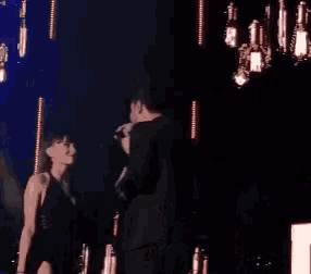 a man and a woman are on a stage with a microphone .
