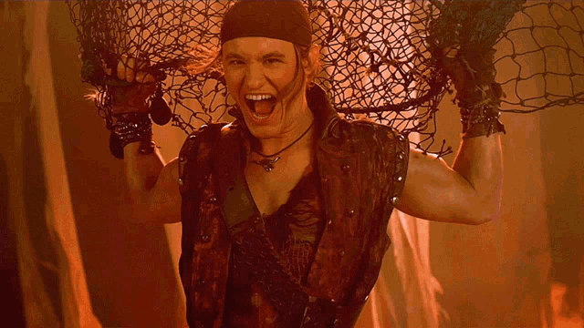 a man wearing a red vest is holding a fishing net over his head