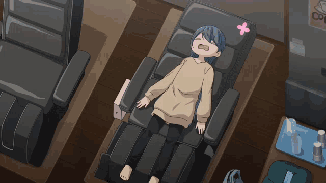 a girl with blue hair is laying in a chair with flowers on her face