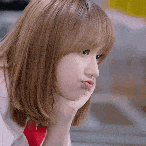 a close up of a woman making a funny face with her hand on her chin