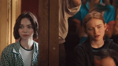 two girls are standing next to each other and one is wearing a plaid jacket