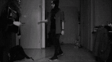 a black and white photo of a man and a woman hugging in a hallway .