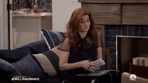 a woman laying on a couch reading a book