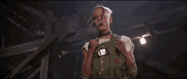 a woman with a bandana on her head is dancing in a dark room .