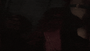 a woman with a choker around her neck is standing in the dark