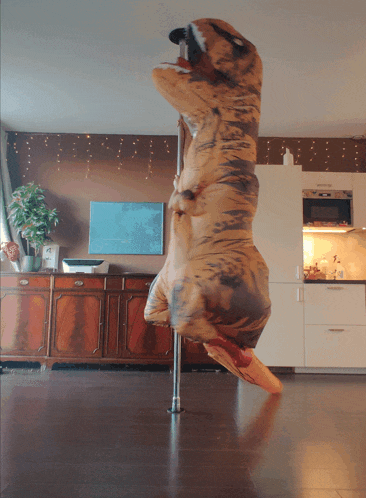 a t-rex costume is on a pole in a living room