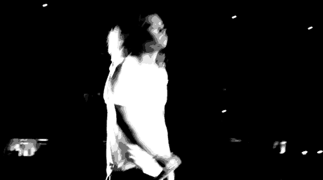 a black and white photo of a fireworks display in the dark .