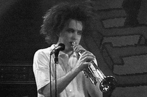 a man is playing a trumpet and singing into a microphone .