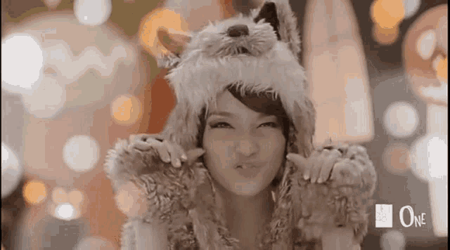 a woman is wearing a furry hat and making a face