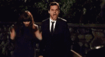 a man in a suit and tie is dancing with a woman