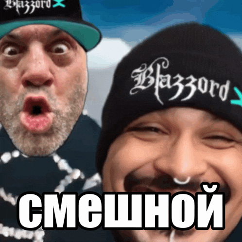 two men are posing for a picture and one has a beanie that says blazzard on it