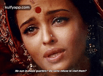 a close up of a woman 's face with a red dot on her forehead and a question .
