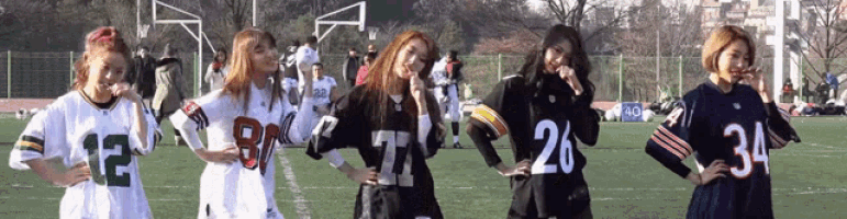 a group of girls wearing football jerseys with the numbers 12 26 and 34