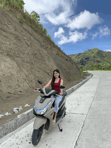 a woman riding a honda scooter on a road
