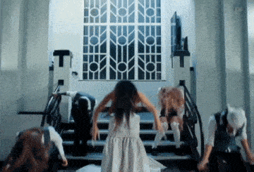 a girl in a white dress is dancing on stairs