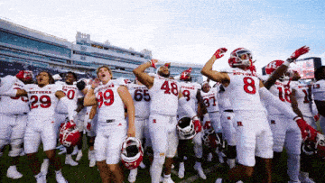 a group of football players wearing white uniforms with the letters r on them