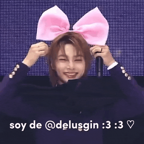 a man wearing a pink bow on his head is smiling