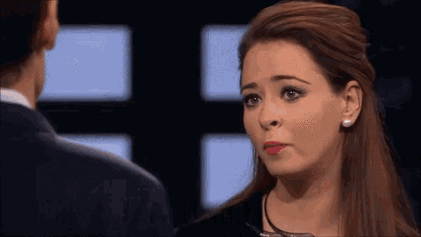 a woman with a sad look on her face looks at a man