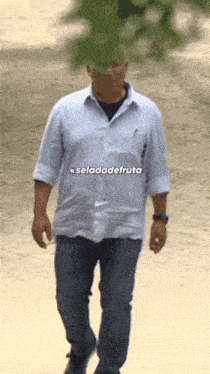 a man in a white shirt is walking down a street with the words " seldadefruta " on the bottom