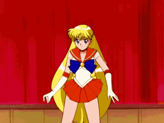 a girl in a sailor moon costume is standing in front of a red curtain