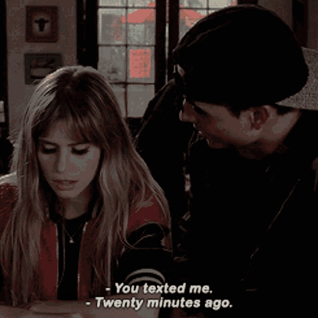 a man and a woman are sitting at a table and the woman is saying you texted me twenty minutes ago