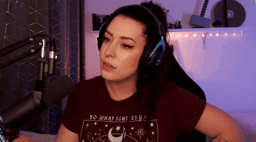 a woman wearing headphones and a t-shirt that says " do what ignites you "