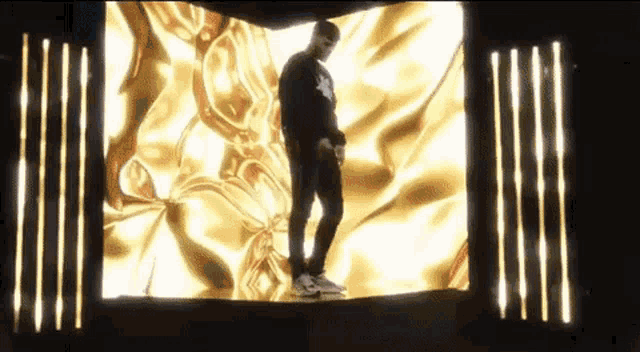 a man is standing in front of a large screen with a yellow background