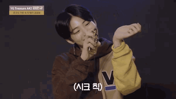 a young man making a heart shape with his hands and a sign that says yg treasure