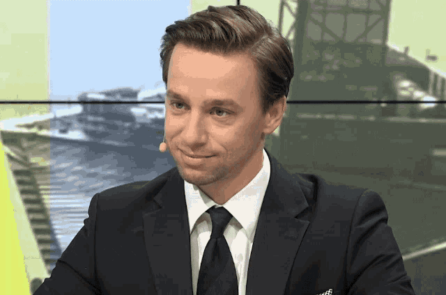 a man in a suit and tie with a microphone in his mouth