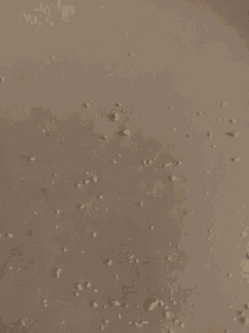 a close up of a white surface with a lot of small pieces of food on it