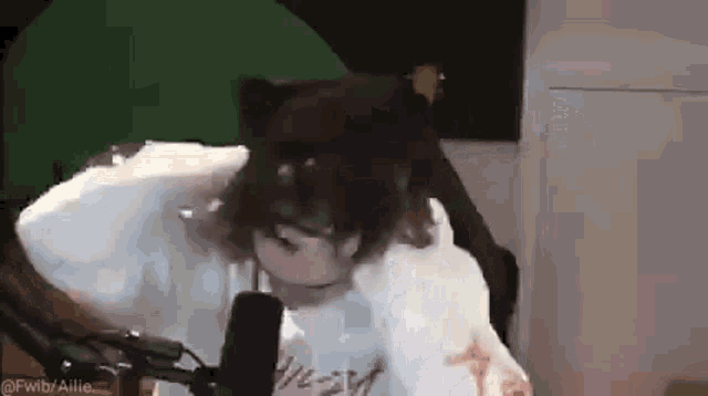 a person is sitting in front of a microphone and making a funny face .