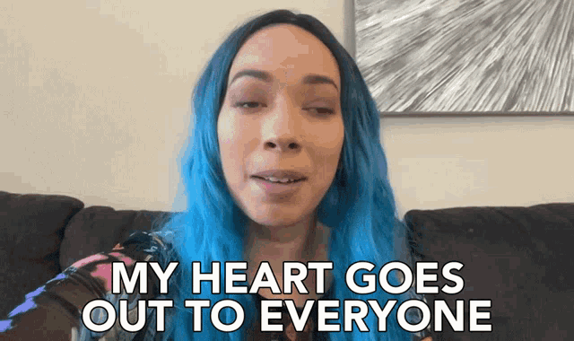 a woman with blue hair is sitting on a couch and saying " my heart goes out to everyone "