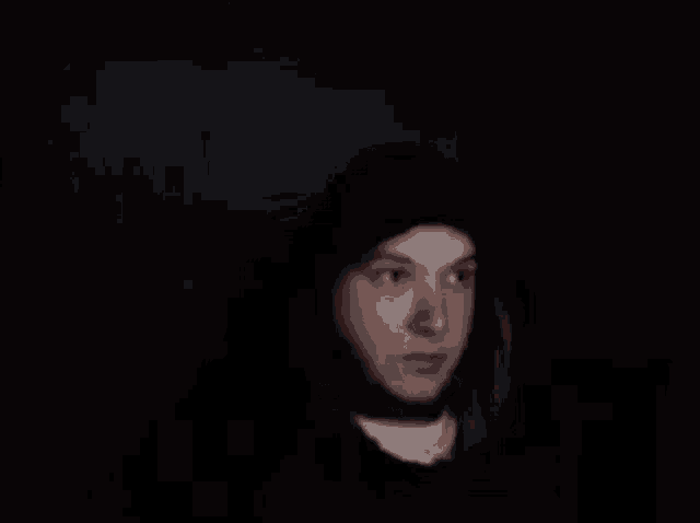 a man wearing a black hat and a red jacket is making a funny face .