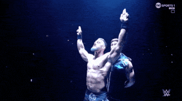 a shirtless wrestler with his arms in the air is on tnt sports 1 live