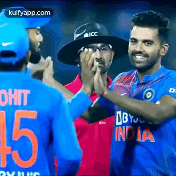 a group of cricket players are giving each other high fives .