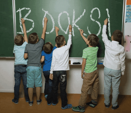a group of young boys are writing the word books on a blackboard